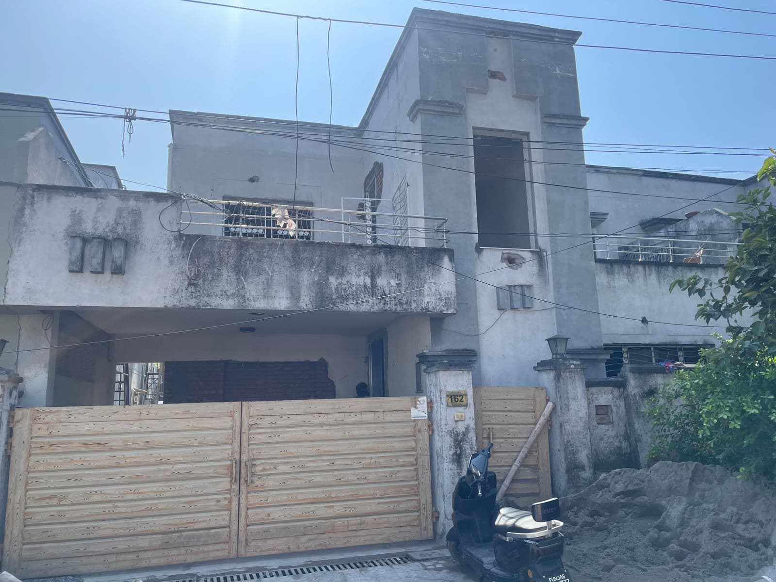 The old front of House #162 in Askari 2, plain grey plaster with wooden gates