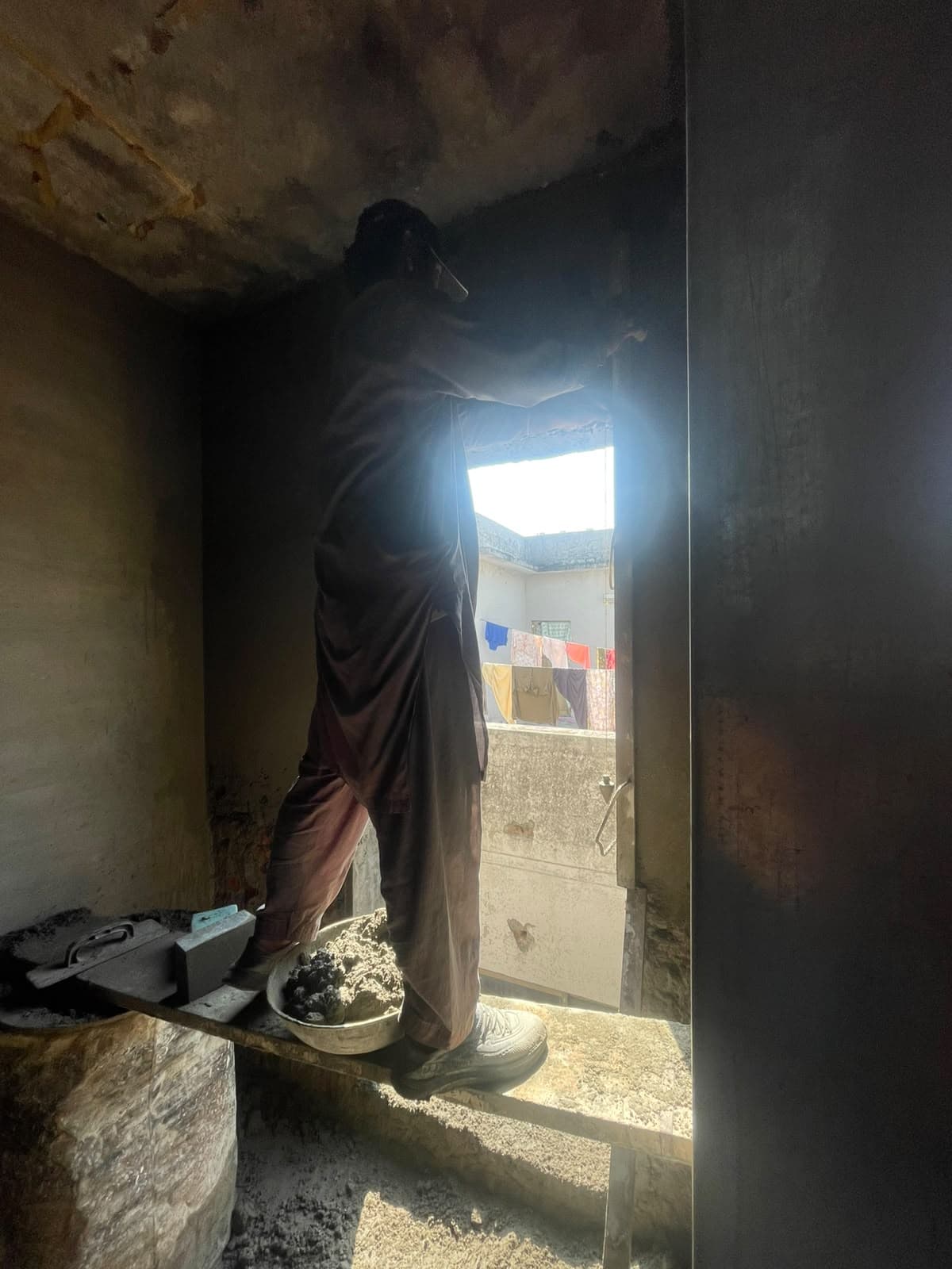 A worker on a plank squaring the top of a new opening