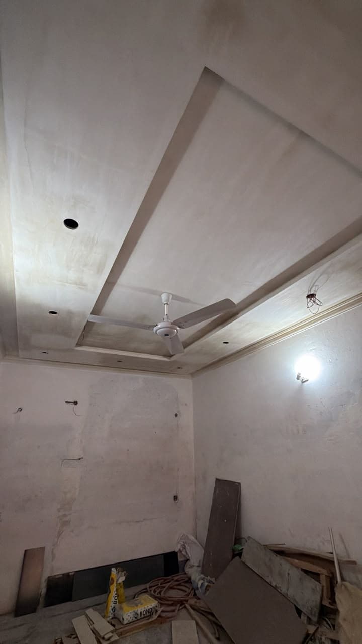 A diagonal stepped false ceiling with downlights in a room being finished