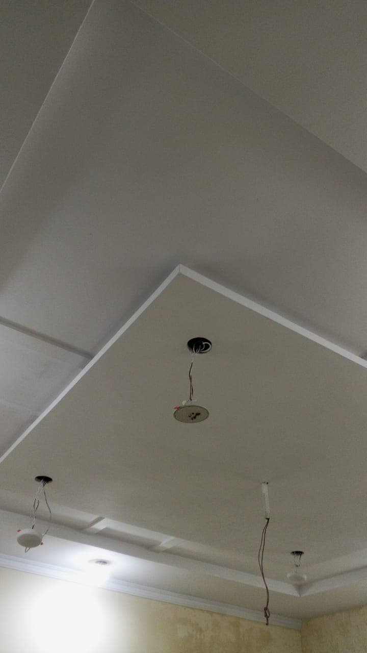 A finished false ceiling with a raised centre panel and downlights