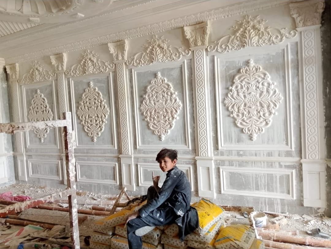 A wall of carved ornamental panels and columns, nearly finished