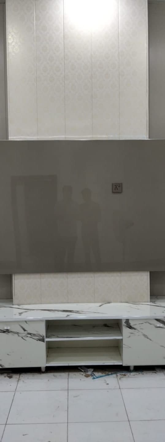 A grey TV wall with a white marble-effect console, newly fitted
