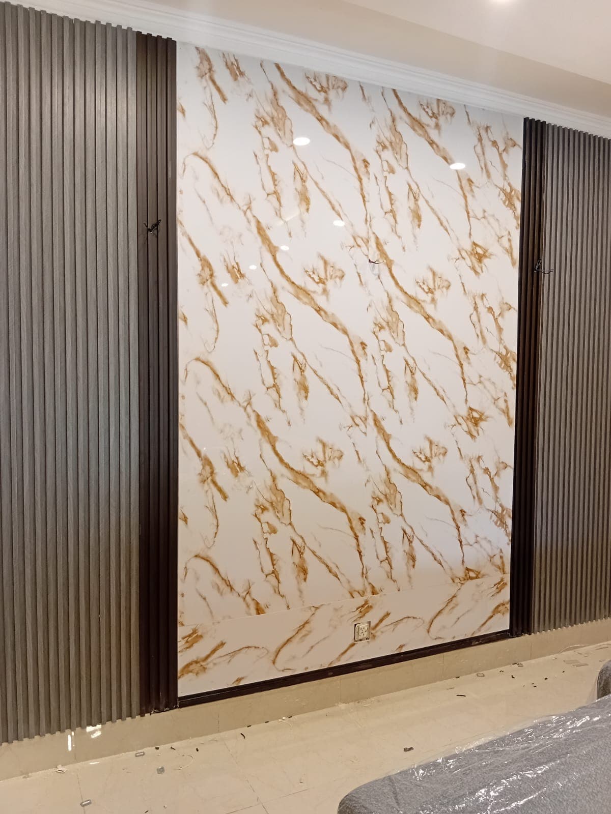 Close-up of the marble-effect panel and the dark fluted panels either side