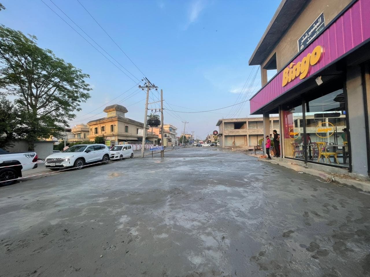 The finished concrete forecourt in front of the shops, looking down the road