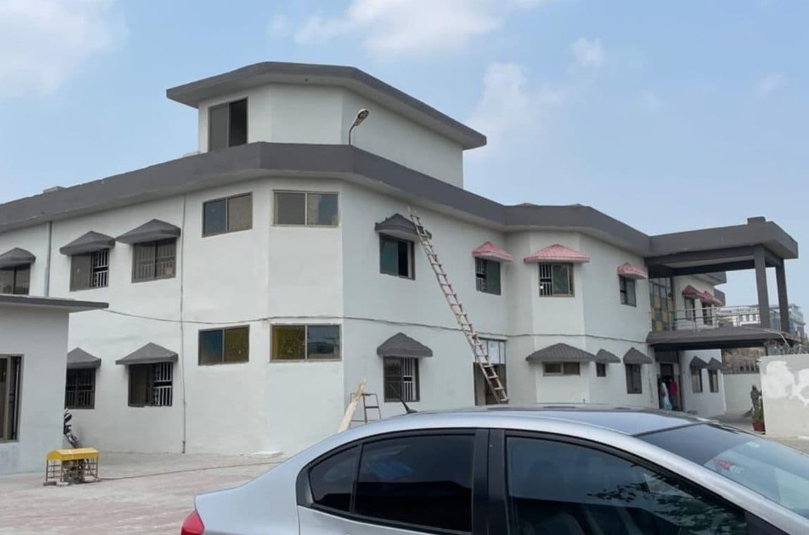 The same building freshly painted white with grey trims and canopies