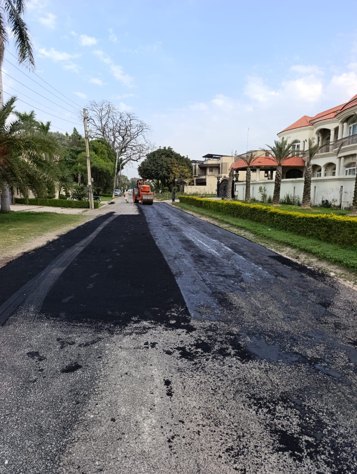 A smooth new asphalt strip down a residential road lined with villas