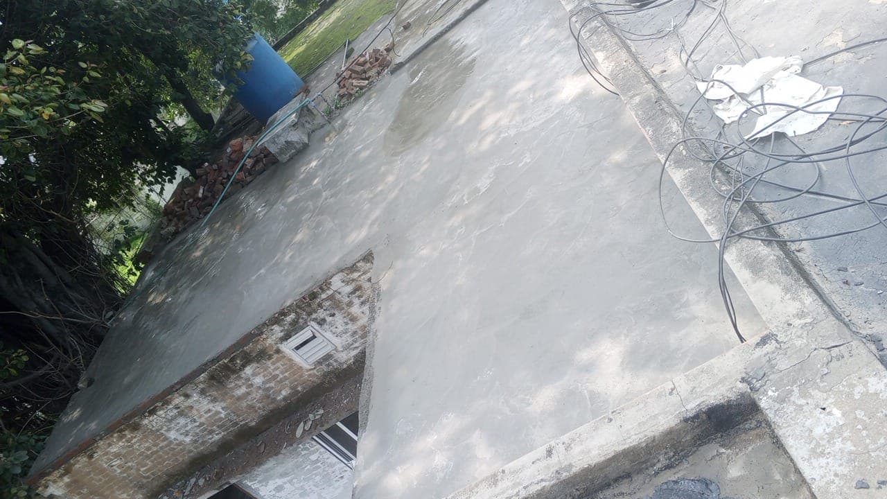 The corner of a flat roof cleaned down to the concrete before treatment