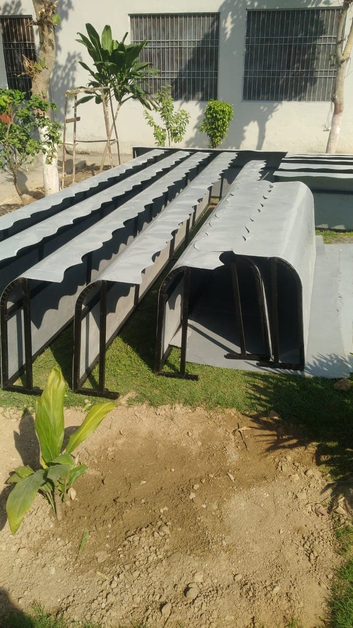 Rows of new steel-framed benches with curved grey seats on a lawn