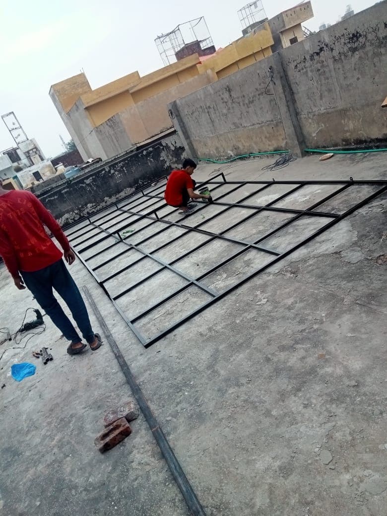 Workers welding the steel lattice frame on the roof