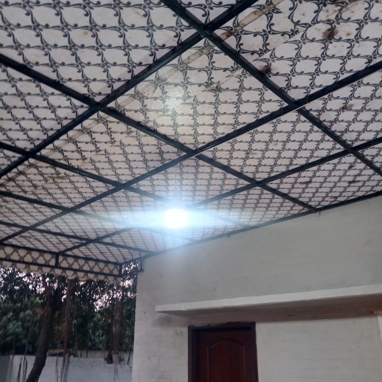 The finished canopy from below, steel lattice over patterned ceiling panels