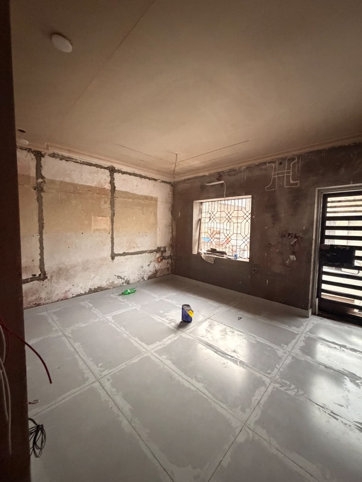 Newly laid floor tiles in a room under renovation, ready for grouting
