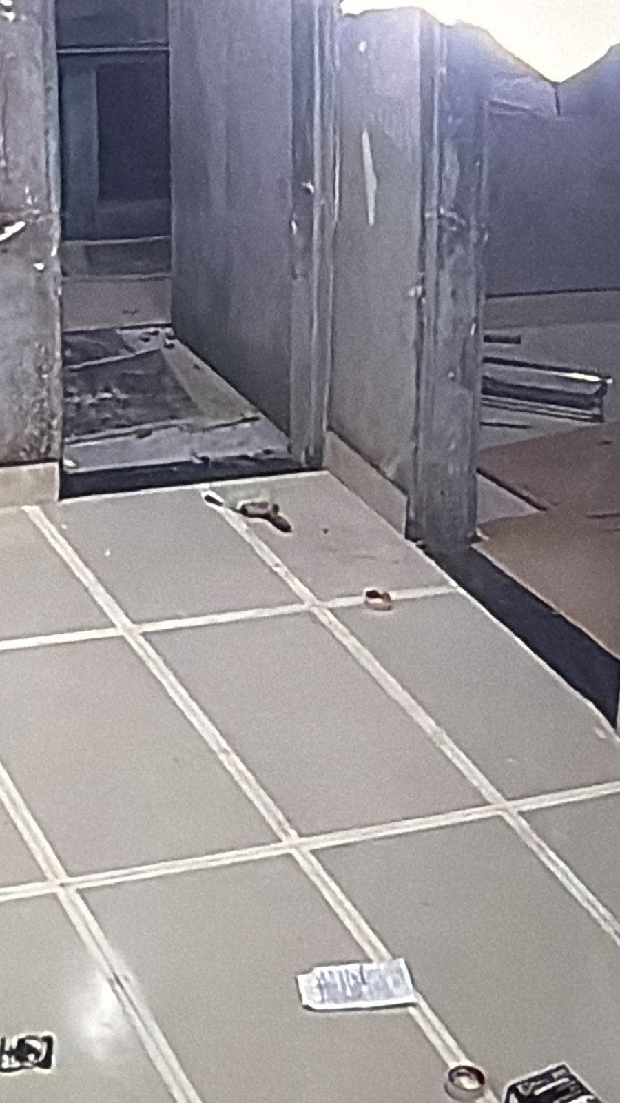Grey floor tiles laid with straight, even joints in a doorway