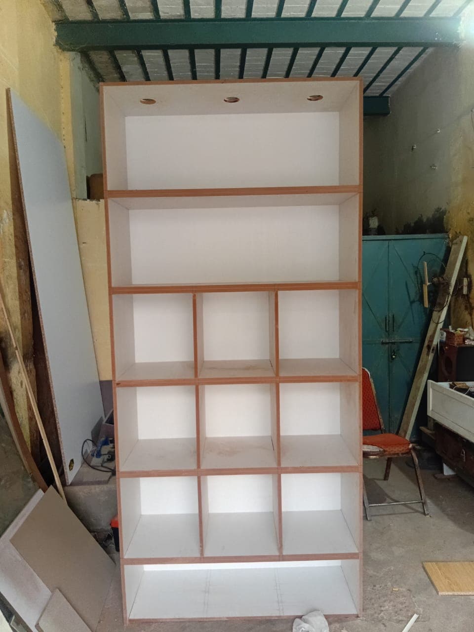 A cube-shelf bookcase carcass standing in the carpentry workshop